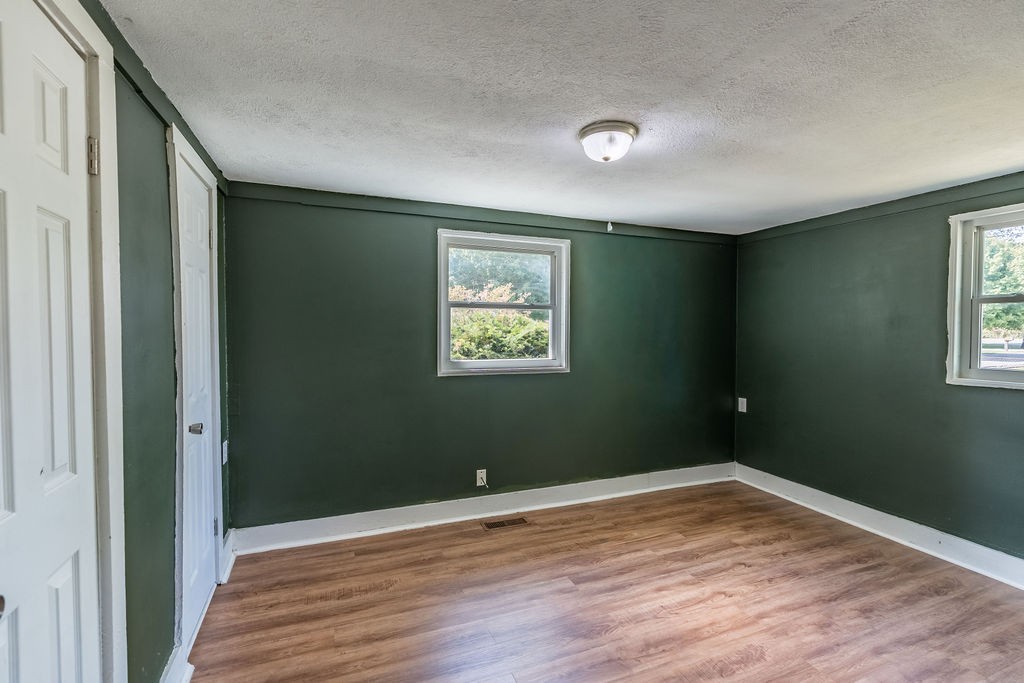 121 Highland School Road Hopkinsville, KY 42240 - Photo 12 of 31 an empty room with wooden floor and windows