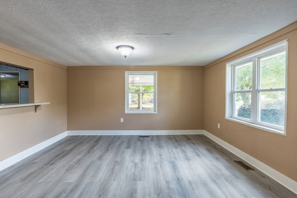121 Highland School Road Hopkinsville, KY 42240 - Photo 4 of 31 an empty room with wooden floor and windows