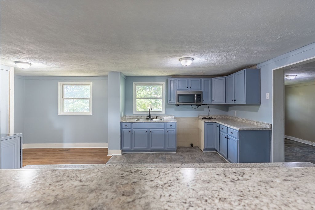 121 Highland School Road Hopkinsville, KY 42240 - Photo 5 of 31 a kitchen with a refrigerator sink cabinets and wooden floor