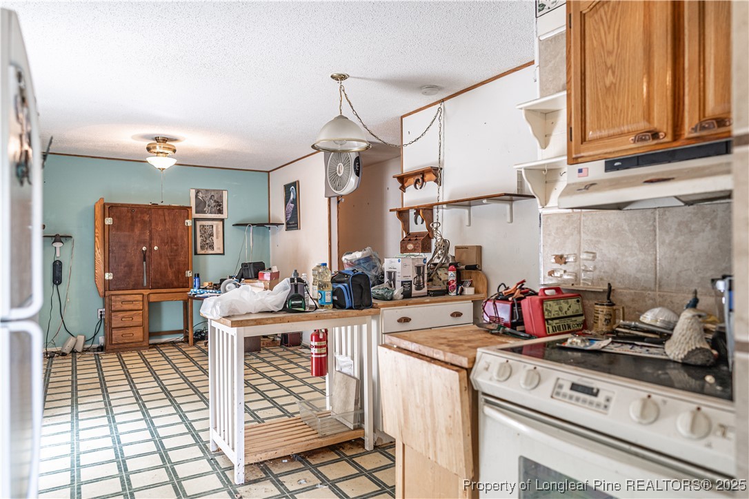 8212 Main Street West End, NC 27376 - Photo 16 of 36 a kitchen with a stove a refrigerator and cabinets
