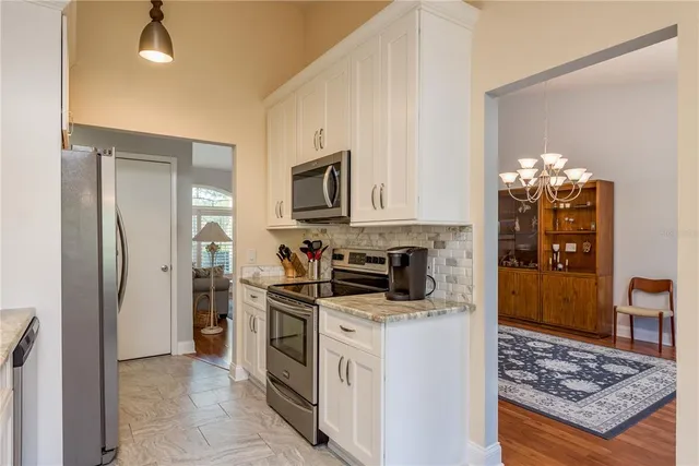 a kitchen with stainless steel appliances granite countertop a refrigerator stove and sink