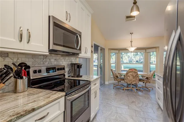 a kitchen with stainless steel appliances kitchen island granite countertop a stove and cabinets