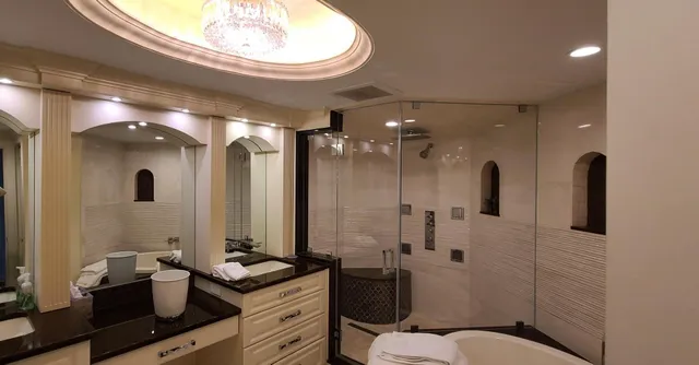 a bathroom with a granite countertop sink a toilet a mirror and shower
