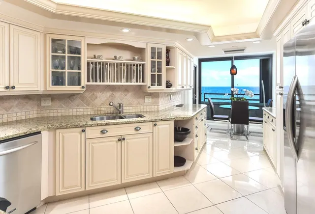 a kitchen with stainless steel appliances granite countertop a stove a sink and a refrigerator