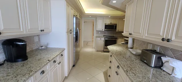a kitchen with granite countertop a sink a stove and cabinets
