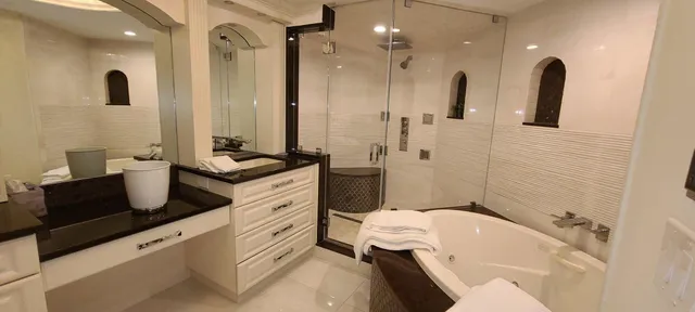 a bathroom with a granite countertop sink mirror bathtub and toilet