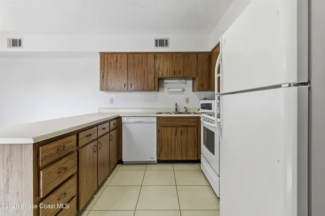 a kitchen with a sink a stove top oven and white stainless steel appliances
