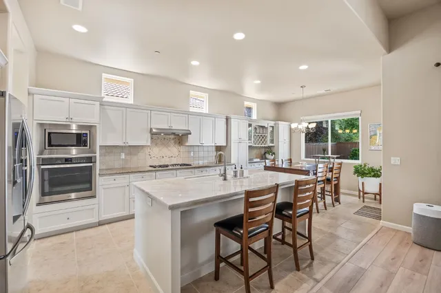 a kitchen with stainless steel appliances kitchen island granite countertop a refrigerator and microwave