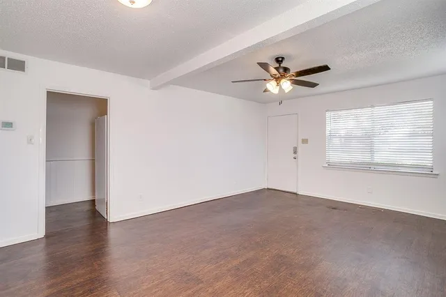 a view of a room with a ceiling fan and a window