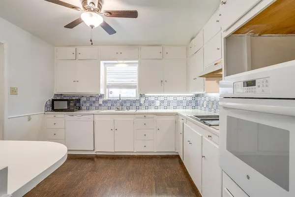 a kitchen with cabinets appliances a sink and a window