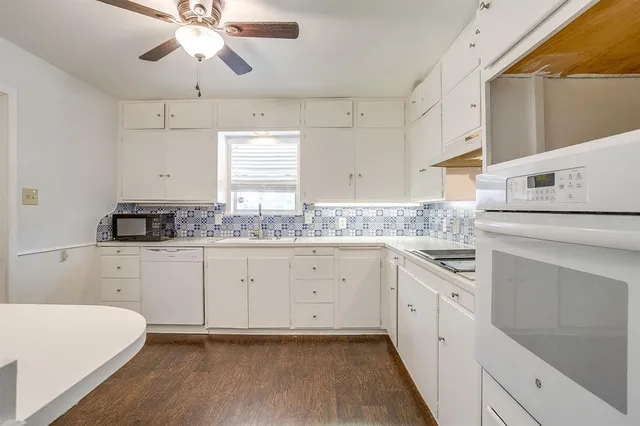 a kitchen with cabinets appliances a sink and a window