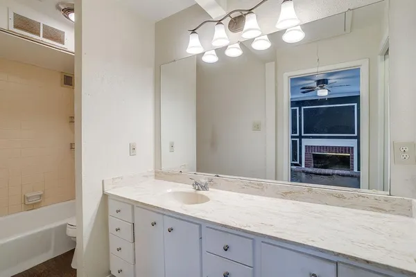 a bathroom with a sink a large mirror and a bathtub