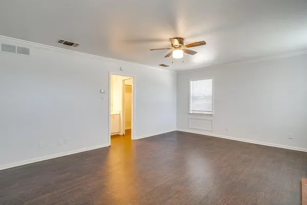 a view of an empty room with window and wooden floor