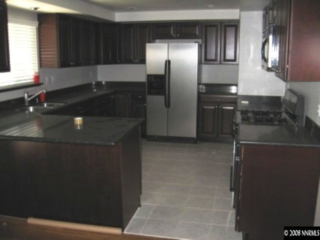 875 Lahontan Way Reno, NV 89509 - Photo 2 of 5 a kitchen with granite countertop stainless steel appliances a sink stove and refrigerator