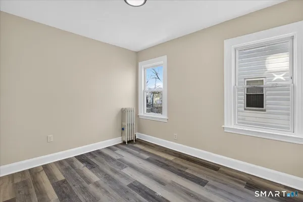 a view of a room that has a window and wooden floor