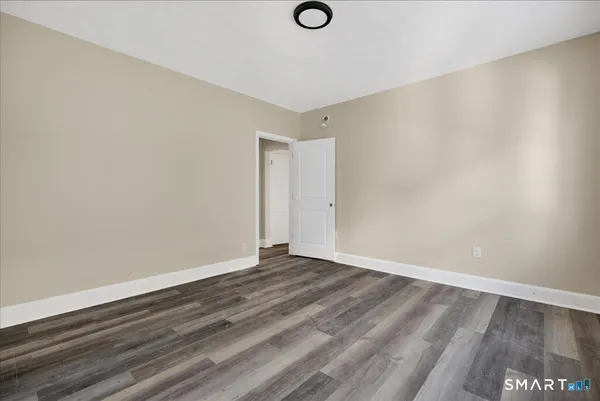 a view of an empty room with wooden floor