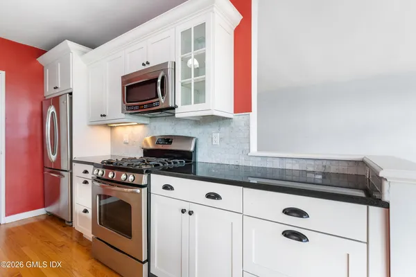 a kitchen with stainless steel appliances granite countertop a stove a microwave and a refrigerator