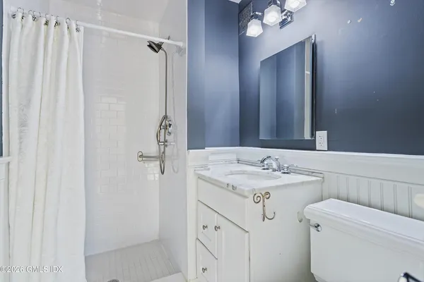 a bathroom with a sink vanity mirror and toilet