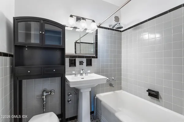 a bathroom with a sink a toilet a mirror and shower
