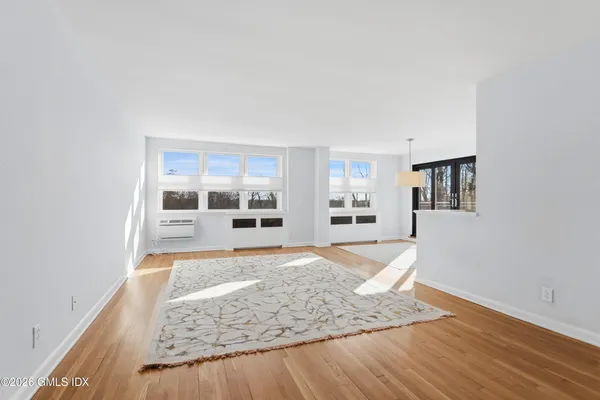 a view of a bedroom with wooden floor and windows