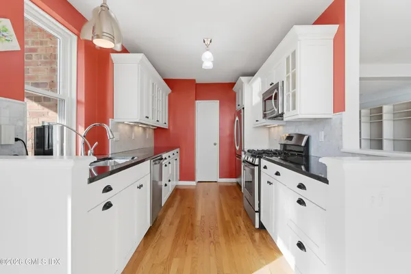 a open kitchen with stainless steel appliances granite countertop a stove and a sink