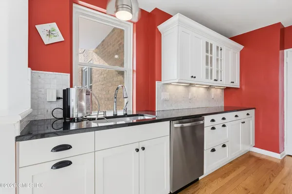 a kitchen with stainless steel appliances granite countertop a sink and dishwasher with wooden cabinets