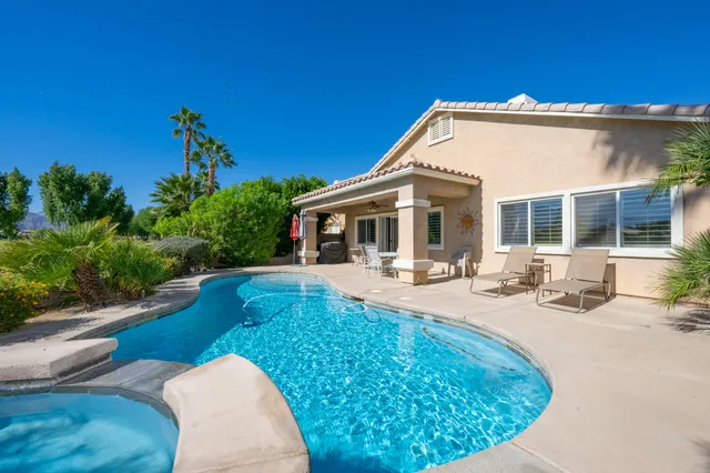 a view of a house with swimming pool and sitting area