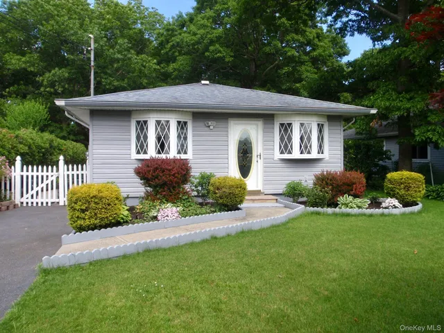 a front view of a house with a yard and outdoor seating