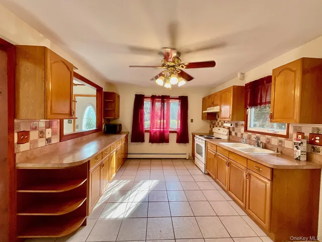a large kitchen with kitchen island granite countertop a large window and stainless steel appliances