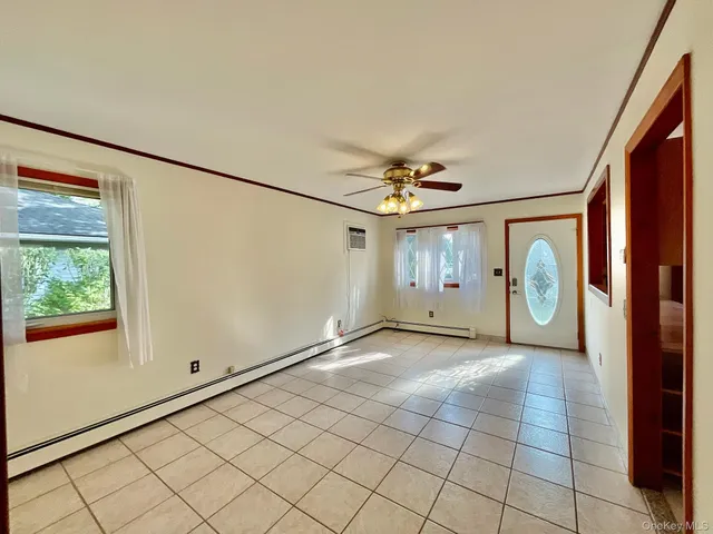 an empty room with windows and fan