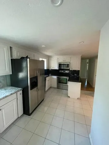 a kitchen with stainless steel appliances a refrigerator sink stove and cabinets