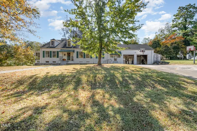 a front view of a house with a garden and trees