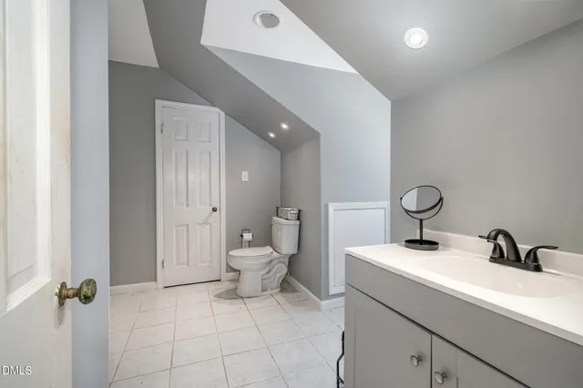a bathroom with a sink mirror and toilet