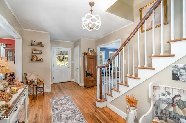 a view of a hallway with wooden floor and staircase