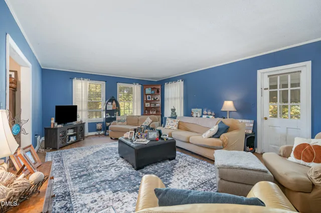 a living room with furniture flat screen tv and a large window