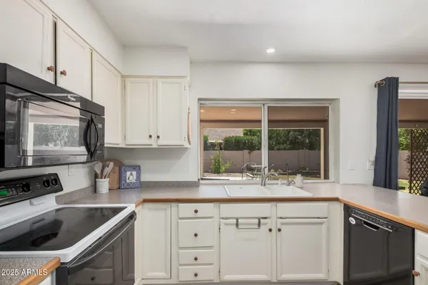 a kitchen with granite countertop a sink stainless steel appliances and cabinets