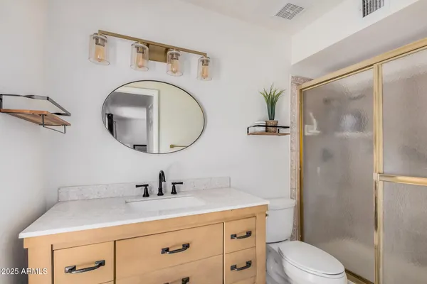 a bathroom with a sink a toilet and a mirror