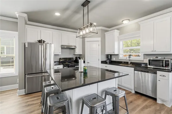 a kitchen with refrigerator cabinets dining table and chairs
