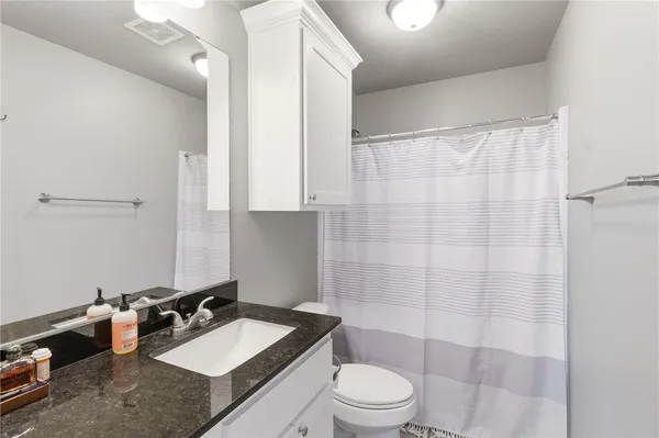 a bathroom with a sink a toilet and shower curtain