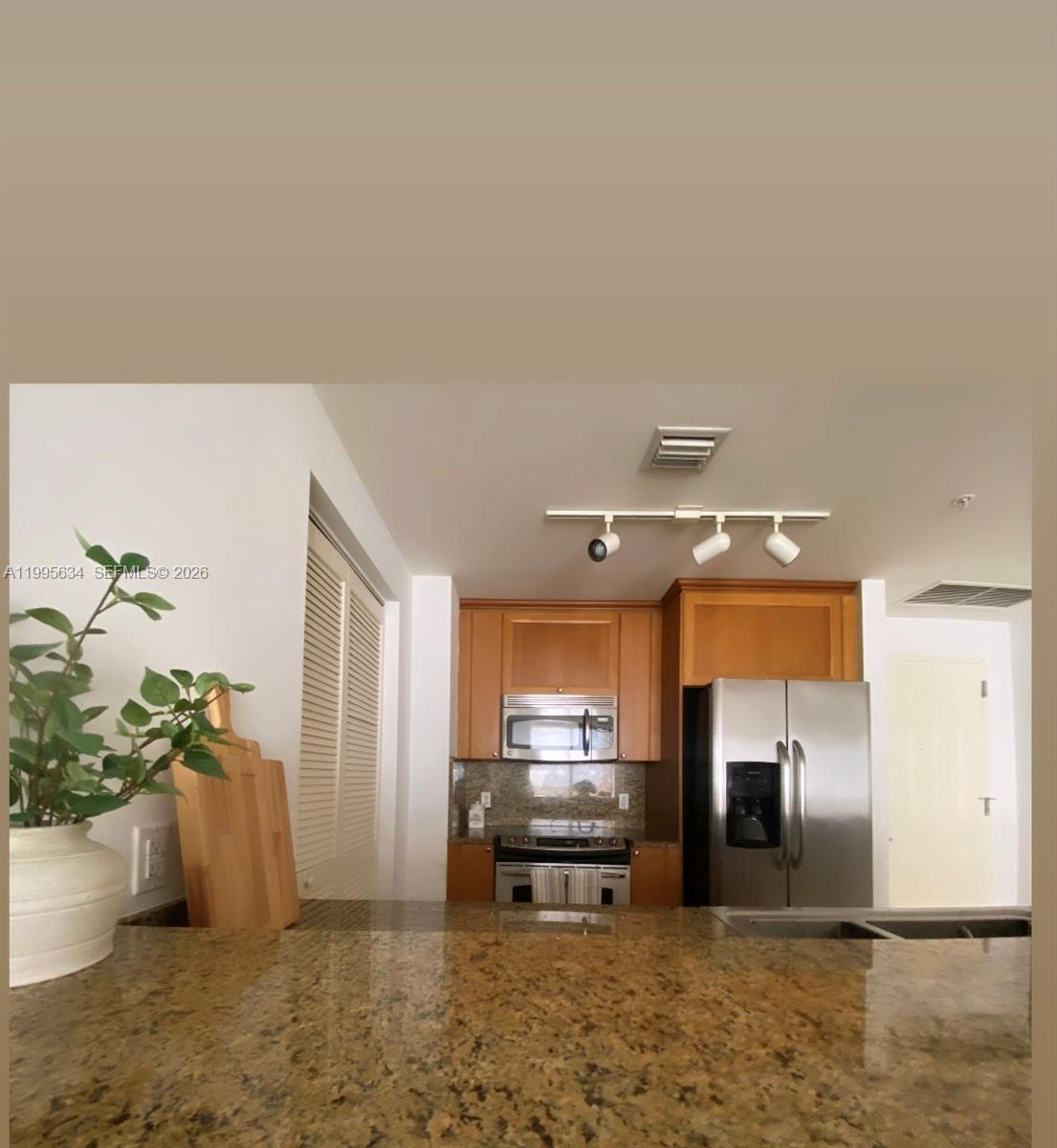55 Merrick Way, Unit 800 Coral Gables, FL 33134 - Photo 11 of 33 a kitchen with granite countertop a refrigerator and a sink
