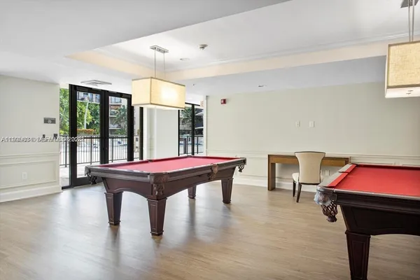 a room with pool table windows and wooden floor