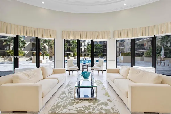 a living room with furniture a lamp and large window