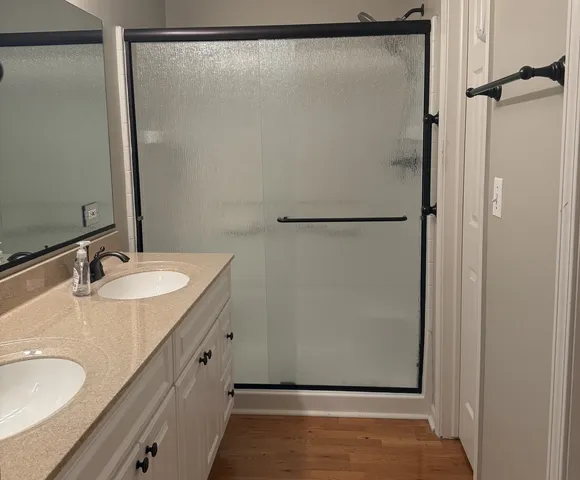 a bathroom with a granite countertop shower sink and mirror