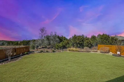a large white kitchen with a stove a sink dishwasher and a refrigerator with white cabinets