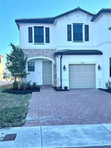 a front view of a house with yard and parking