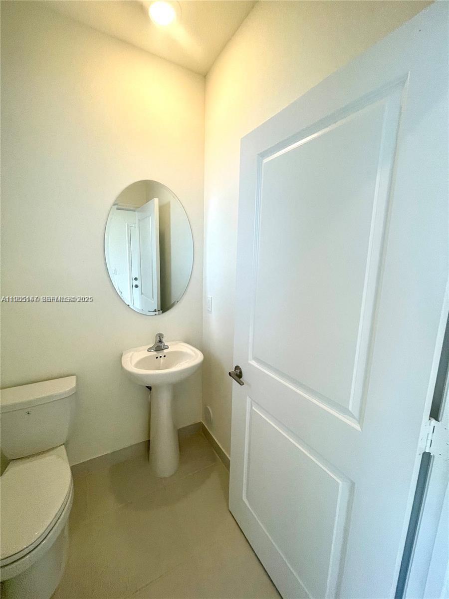 3338 West 112th Street Hialeah, FL 33018 - Photo 4 of 40 a bathroom with a toilet sink and mirror