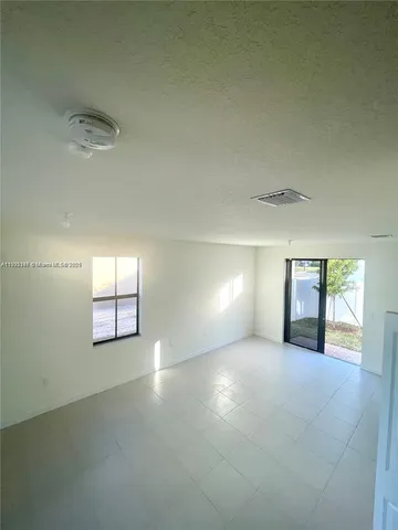 an empty room with windows and fireplace