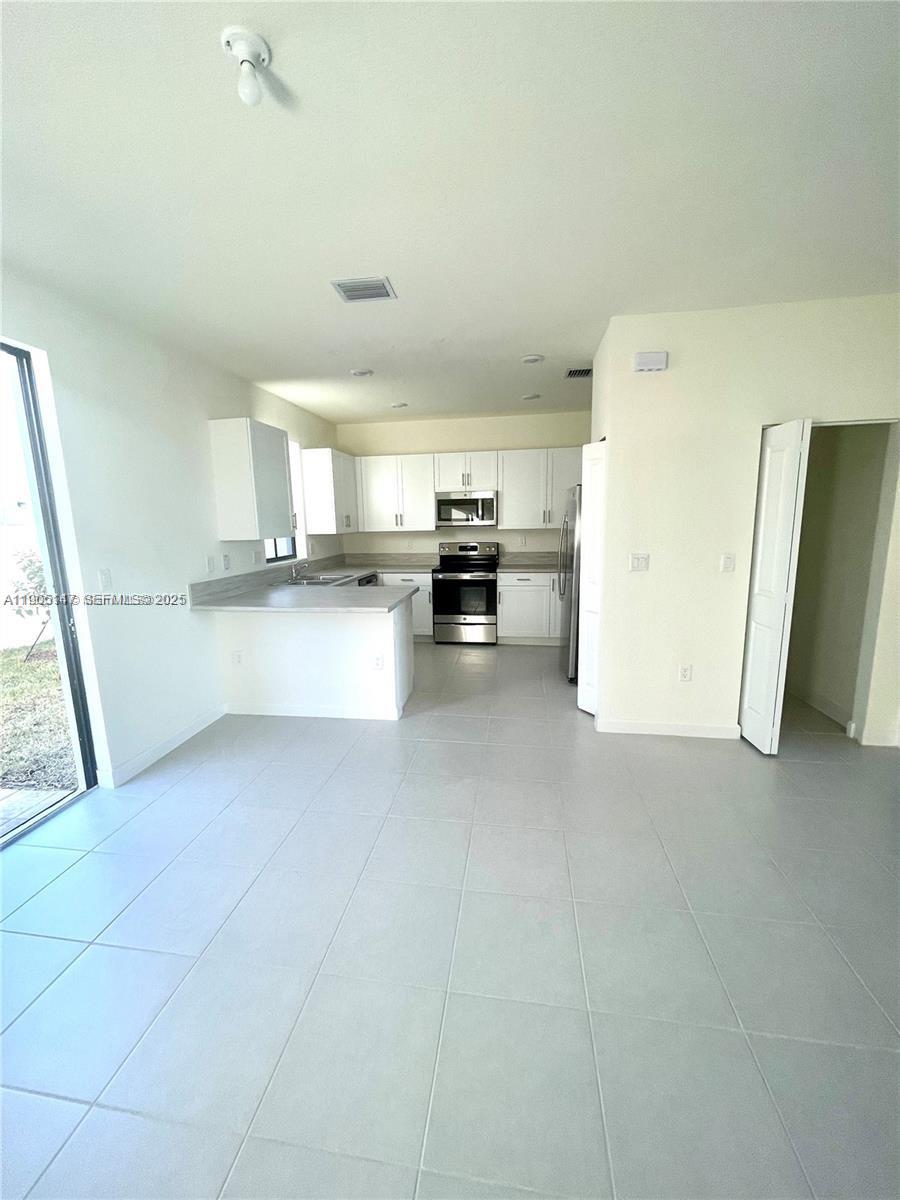 3338 West 112th Street Hialeah, FL 33018 - Photo 8 of 40 a kitchen with a sink and a refrigerator