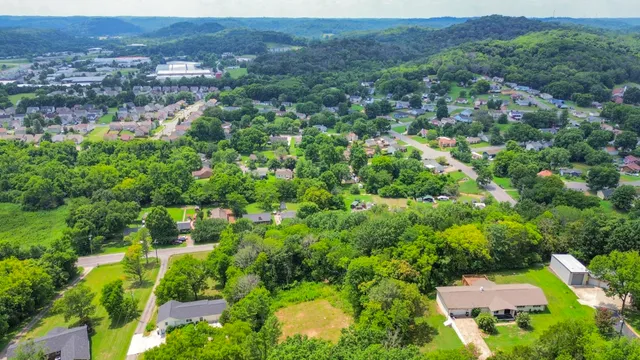 an aerial view of residential house with outdoor space and trees all around