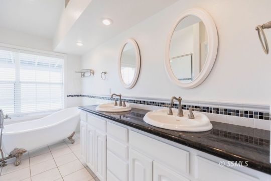919 Beverly Court Ridgecrest, CA 93555 - Photo 20 of 29 a bathroom with a double vanity sink a mirror and a bathtub